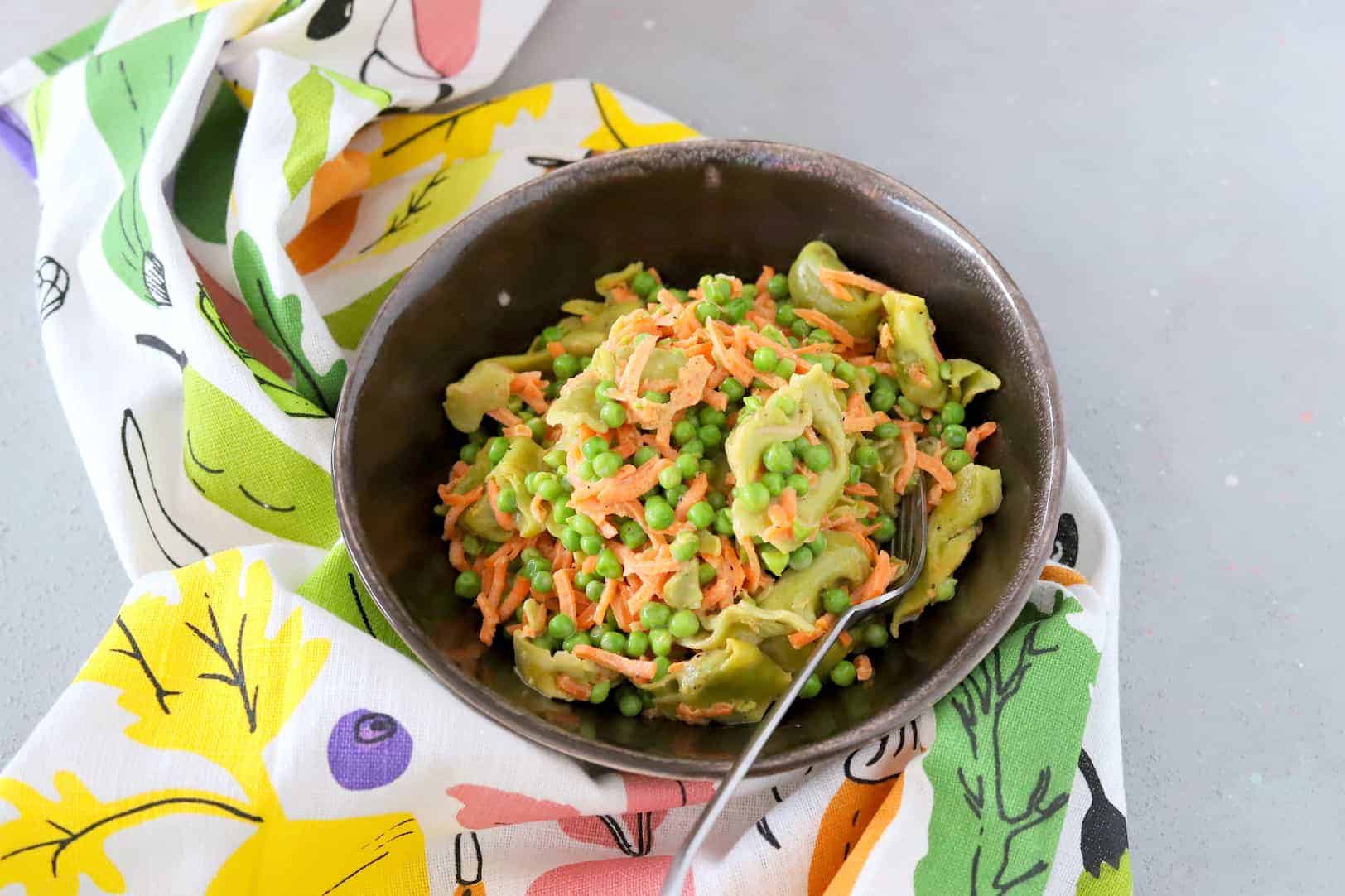 Romige tortellini met doperwten en wortel